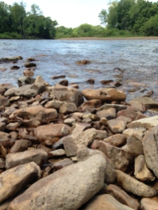 The gentle river flow across the rocky shore line.